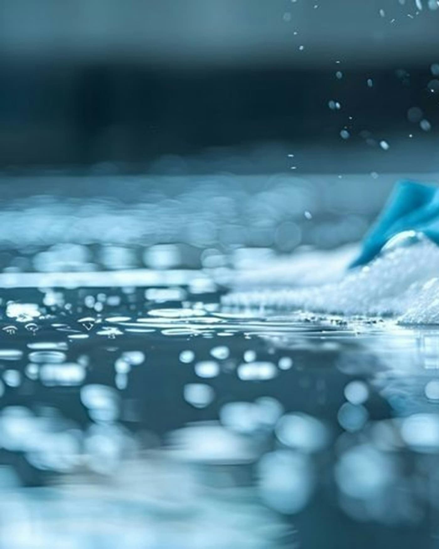 Main gantée jaune récurant une surface avec mousse et éponge